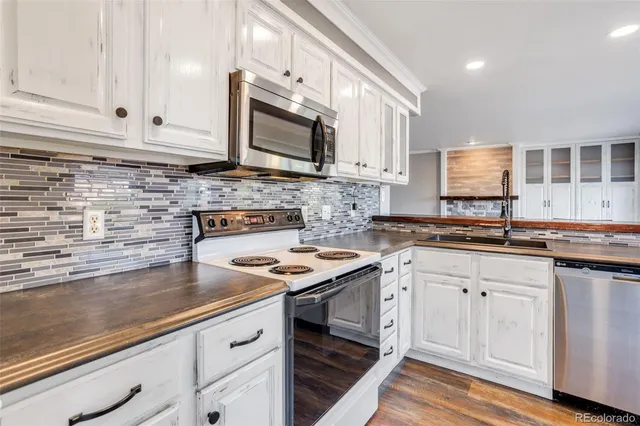 a kitchen with stainless steel appliances granite countertop a sink stove and cabinets