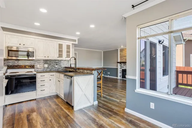 a kitchen with stainless steel appliances granite countertop a stove a sink and a refrigerator