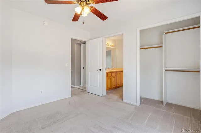 an empty room with chandelier fan