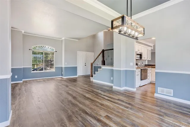 a view of a kitchen with wooden floor and a chandelier