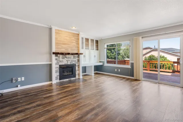 wooden floor fireplace and windows in an empty room