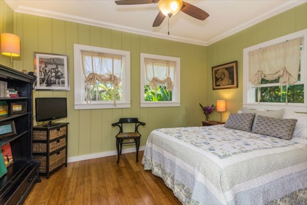 5175 Weke Road Hanalei, HI 96714 - Photo 20 of 25 a bedroom with a bed a computer on the desk and a book shelf