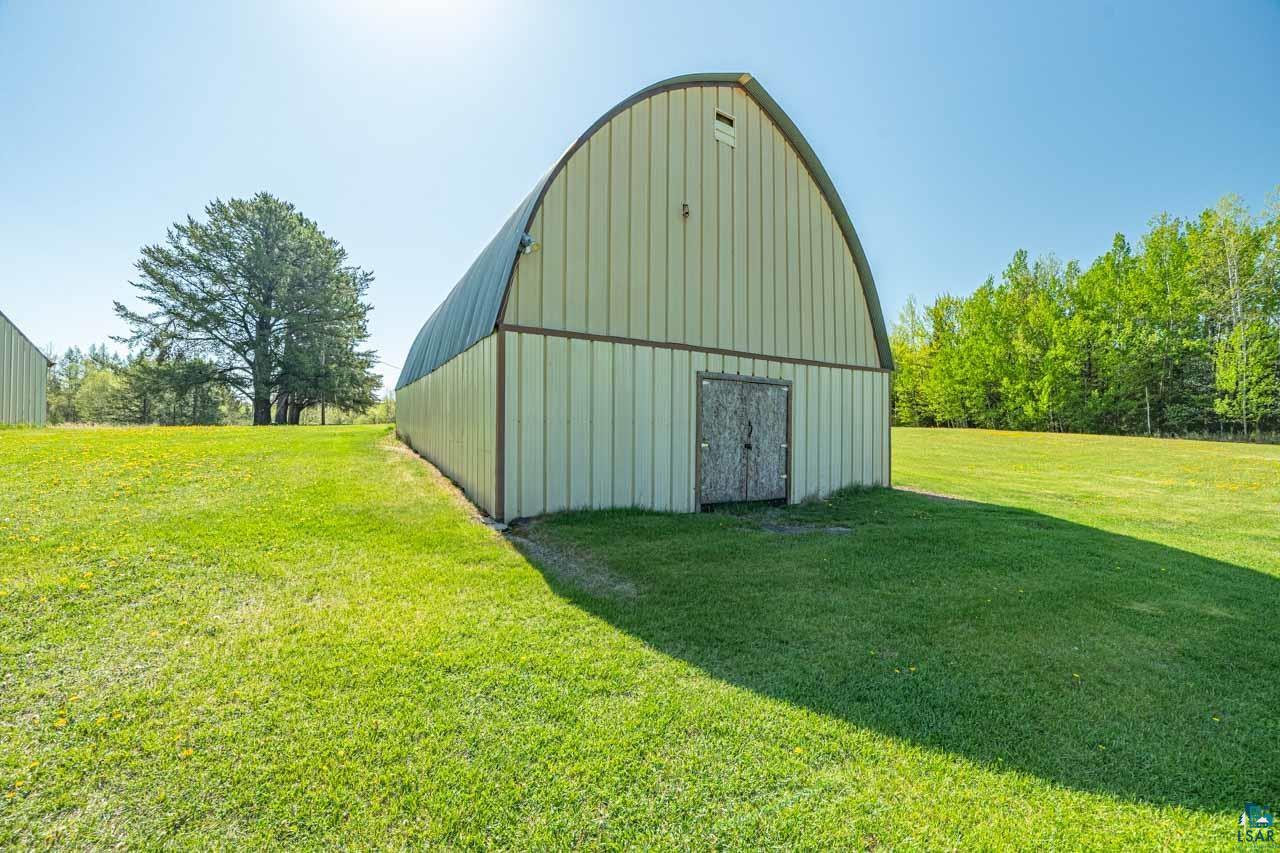 2581 O'Rourke Road Hibbing, MN 55746 - Photo 37 of 61 Quonset-style utility building featuring a corrugated metal exterior with a curved roofline and a distressed wood entry door
