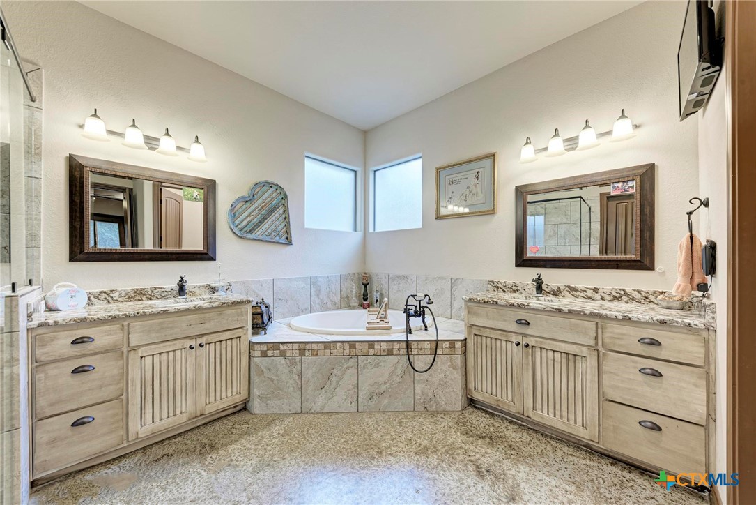 1325 County Road 106 Lampasas, TX 76550 - Photo 23 of 48 a bathroom with a double vanity sink mirror and bathtub