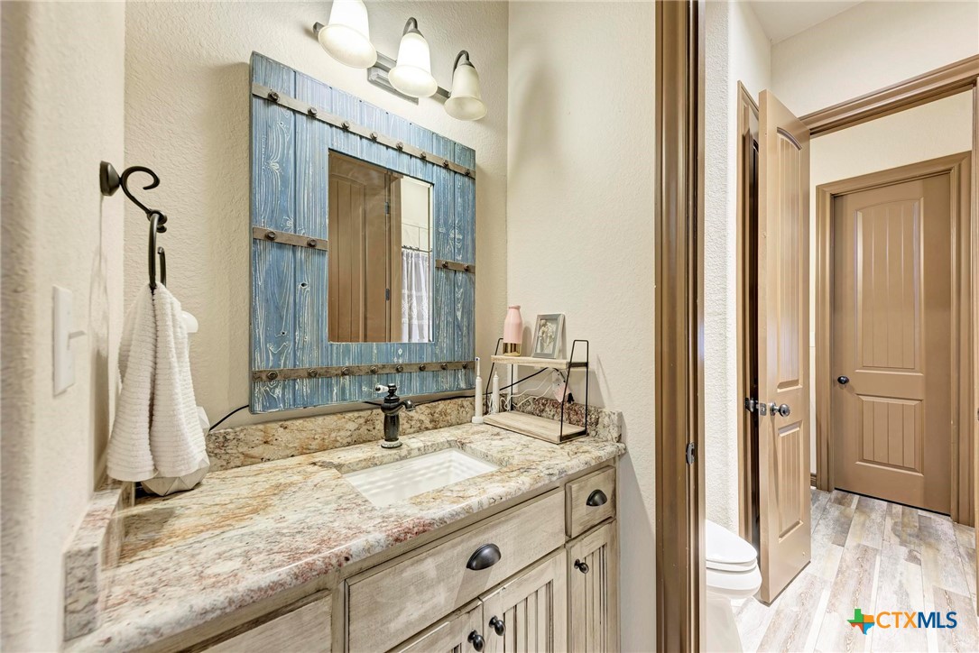 1325 County Road 106 Lampasas, TX 76550 - Photo 31 of 48 a bathroom with a granite countertop sink and a mirror