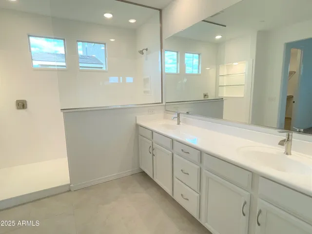 a bathroom with double sink and a mirror