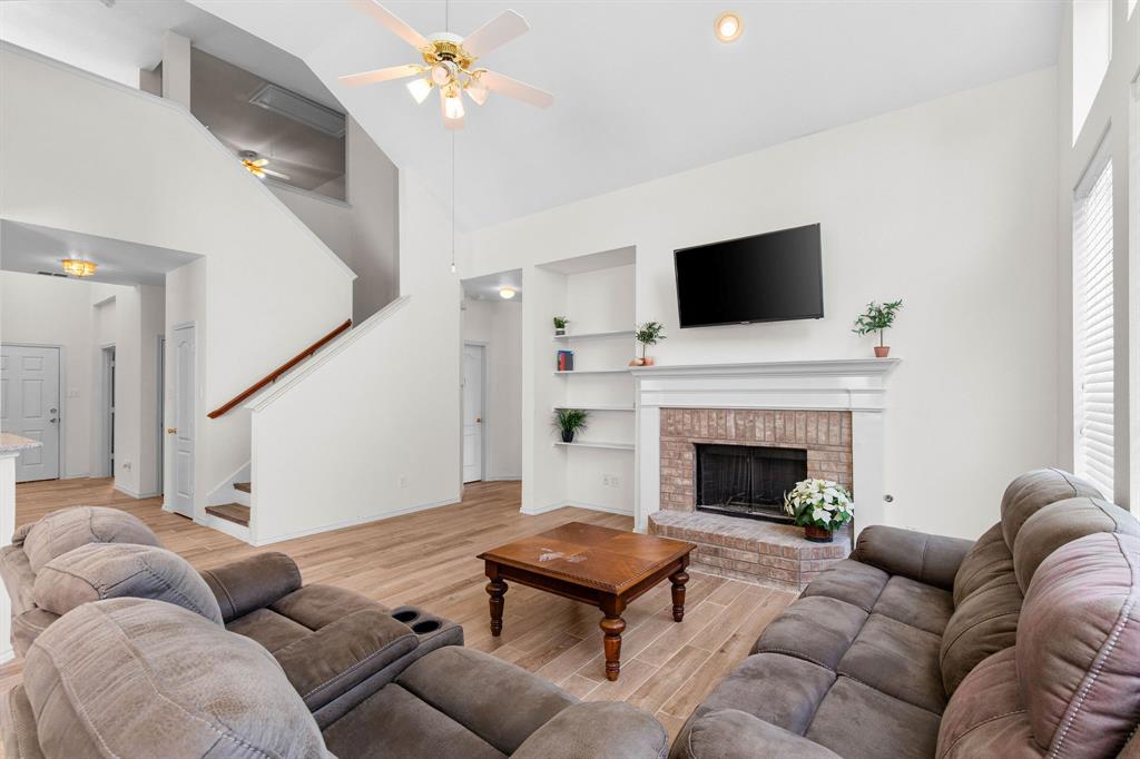 2700 Hereford Road Denton, TX 76210 - Photo 7 of 36 Living area featuring a brick fireplace with a white mantel, wood-finish flooring, and a ceiling fan