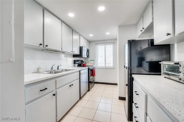 a kitchen that has a lot of cabinets in it and appliances