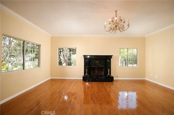a living room with a fireplace and wooden floor