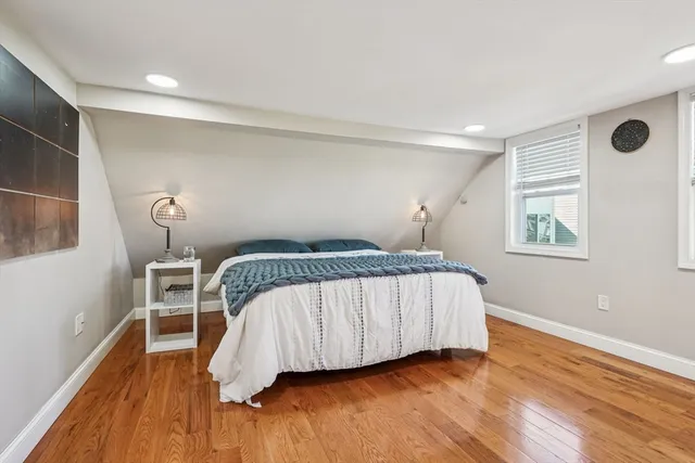 a bedroom with a bed and wooden floor