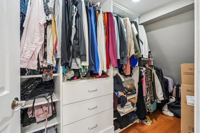 a view of walk in closet with clothes and shoes