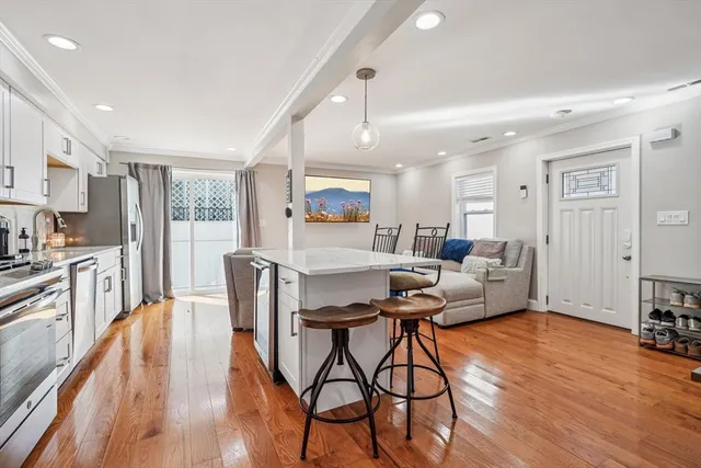 a living room with furniture wooden floor and a large window