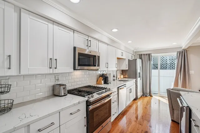 a kitchen with stainless steel appliances granite countertop a stove a sink dishwasher and a refrigerator