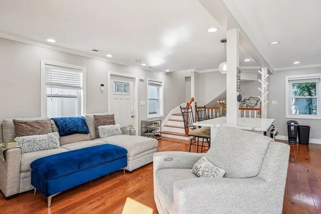 a living room with furniture and a wooden floor