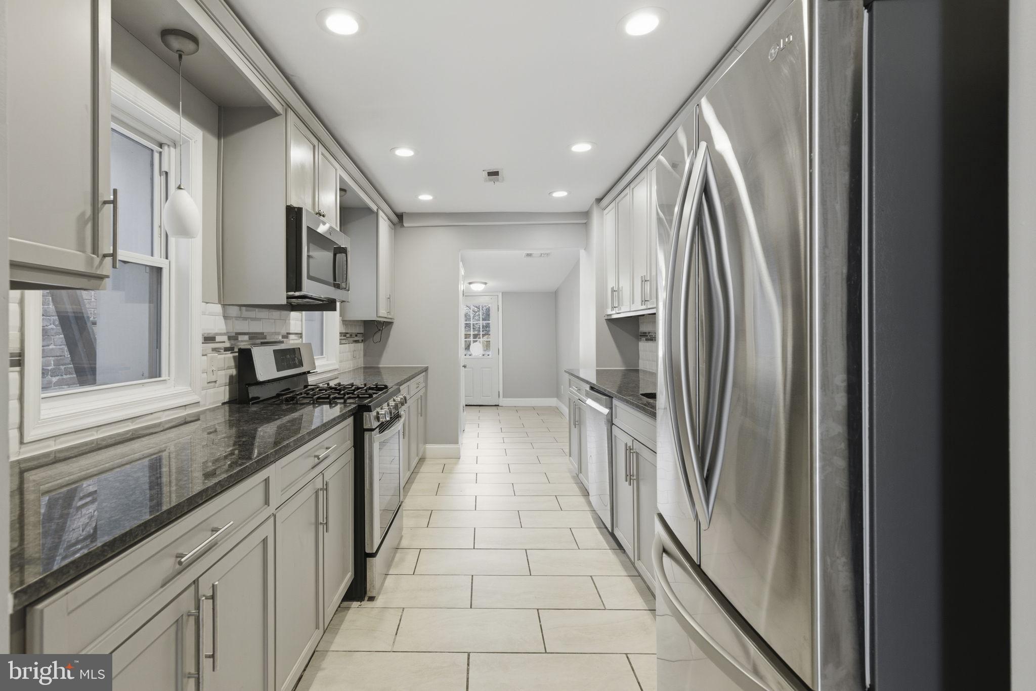 a large kitchen with a large counter top a stove and a refrigerator
