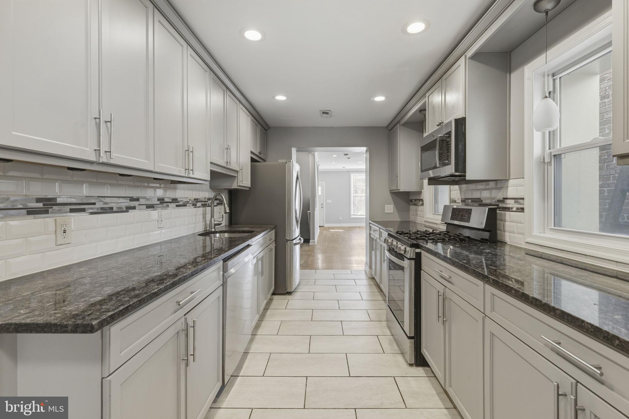 513 Scott Street Baltimore, MD 21230 - Photo 4 of 14 a large kitchen with stainless steel appliances granite countertop a stove sink and cabinets
