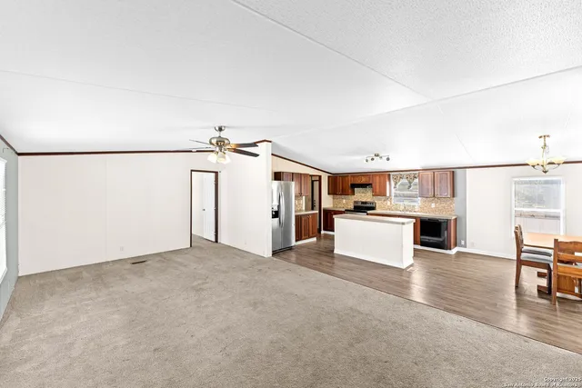 a view of a kitchen with furniture and wooden floor