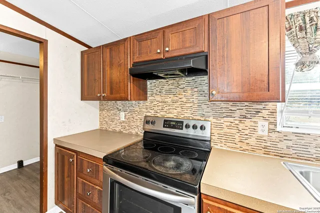 a kitchen with granite countertop cabinets stainless steel appliances and a counter space