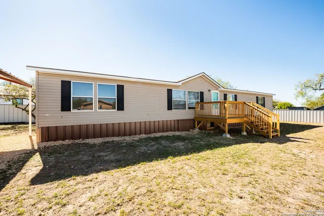 a view of a house with a yard covered in snow