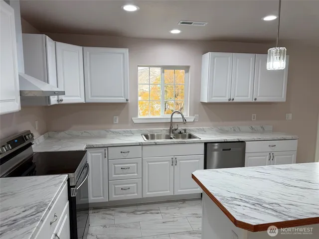 a kitchen with a stove sink and cabinets