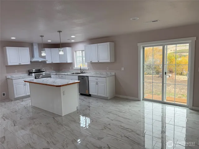 a kitchen with stainless steel appliances granite countertop a stove a sink and a microwave