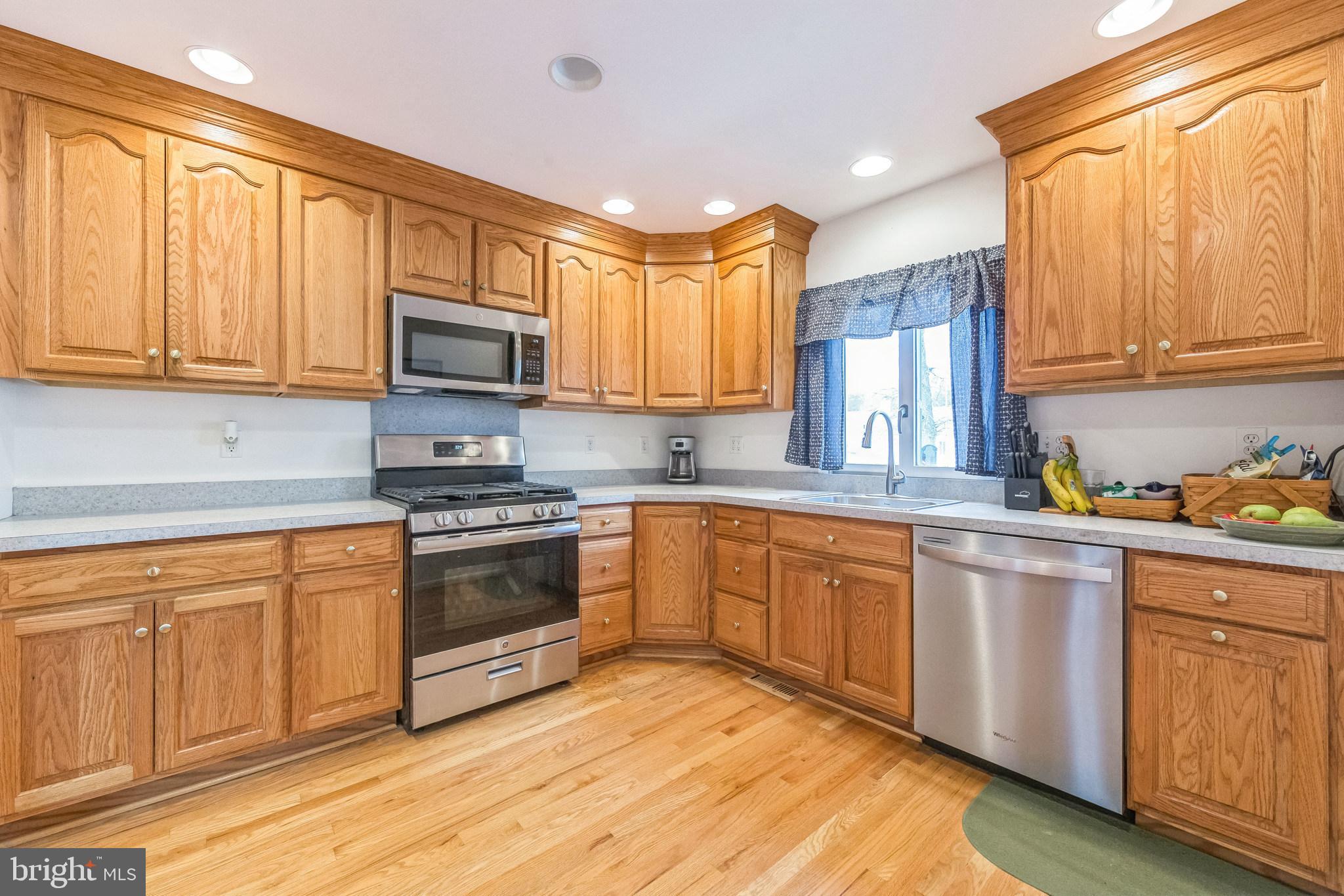 864 Estates Boulevard Hamilton, NJ 08690 - Photo 10 of 15 a kitchen with stainless steel appliances granite countertop a stove a sink dishwasher and a microwave oven with cabinets