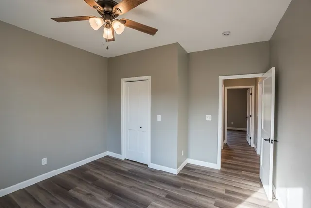 a bathroom with a granite countertop toilet a sink and a mirror