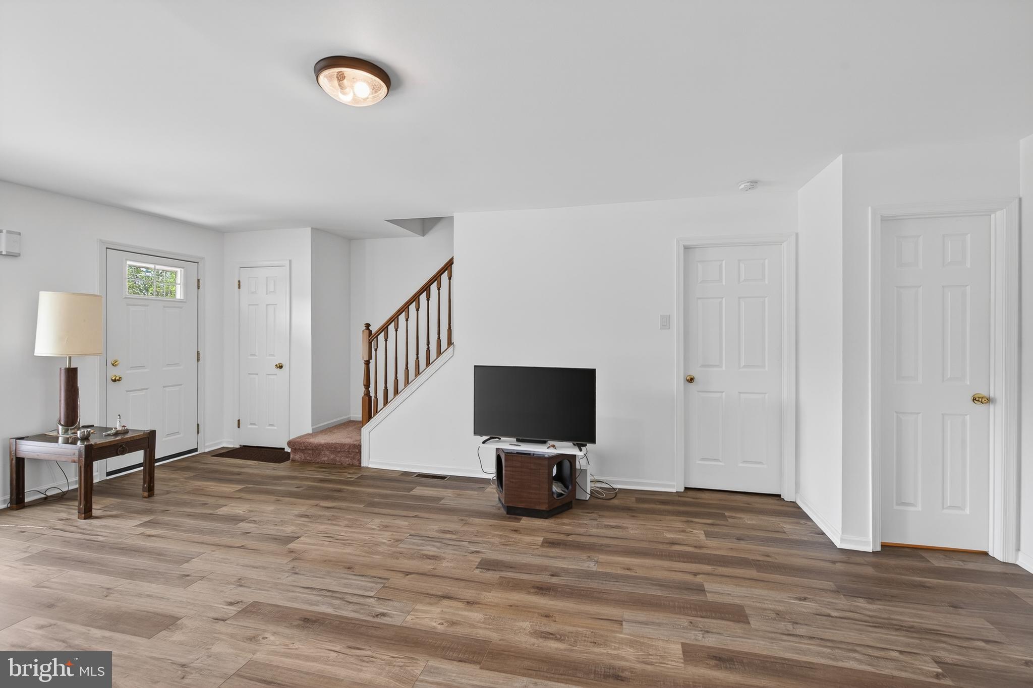 122 Longford Road West Chester, PA 19380 - Photo 7 of 39 a view of a livingroom with a flat screen tv wooden floor and a ceiling fan