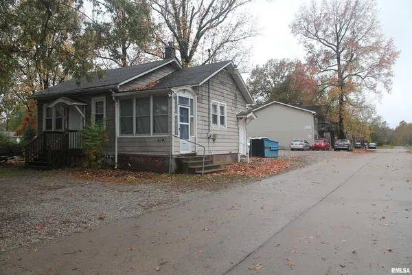 a view of house with a yard and large trees