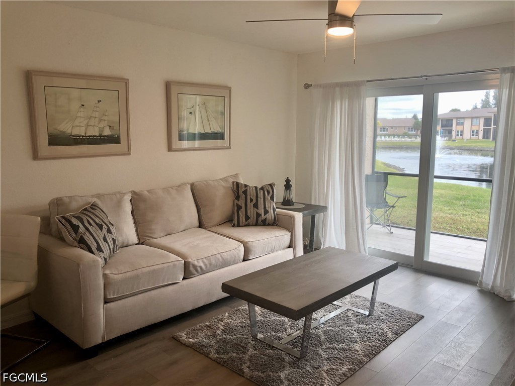16881 Davis Road, Unit 214 Fort Myers, FL 33908 - Photo 13 of 46 a living room with furniture and a large window with wooden floor