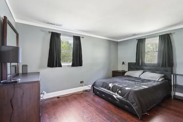 a bedroom with a bed window and mirror
