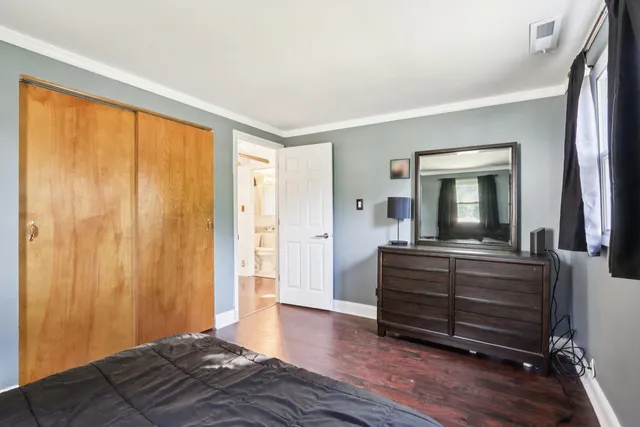 a bedroom with a bed and a mirror on dresser