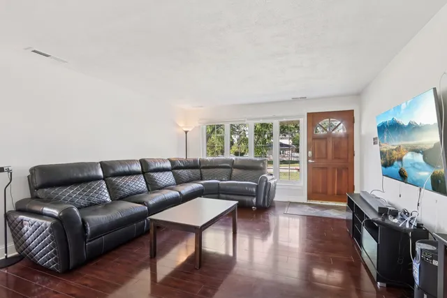 a living room with furniture and a wooden floor