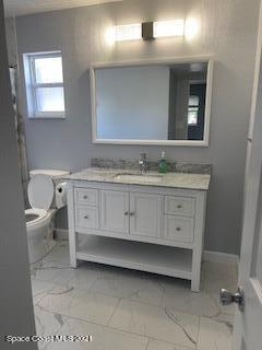 1034 Bali Road Cocoa Beach, FL 32931 - Photo 27 of 40 a bathroom with a granite countertop toilet sink and mirror