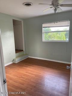 1034 Bali Road Cocoa Beach, FL 32931 - Photo 36 of 40 an empty room with wooden floor and a ceiling fan