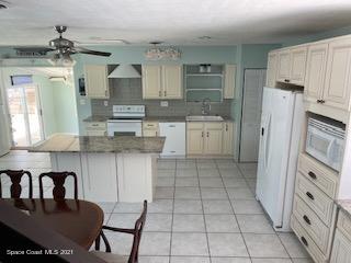 1034 Bali Road Cocoa Beach, FL 32931 - Photo 6 of 40 a kitchen with stainless steel appliances granite countertop a refrigerator and a stove top oven