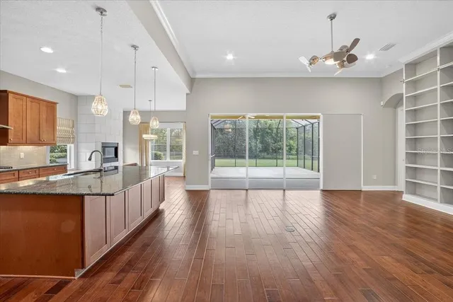 a large white kitchen with wooden floors and wide window