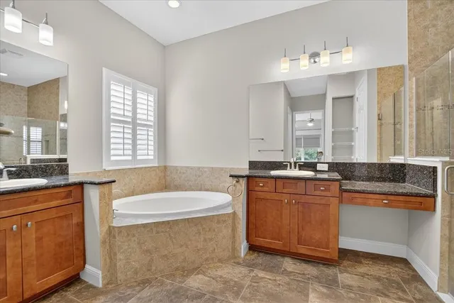 a bathroom with a tub a sink and a mirror