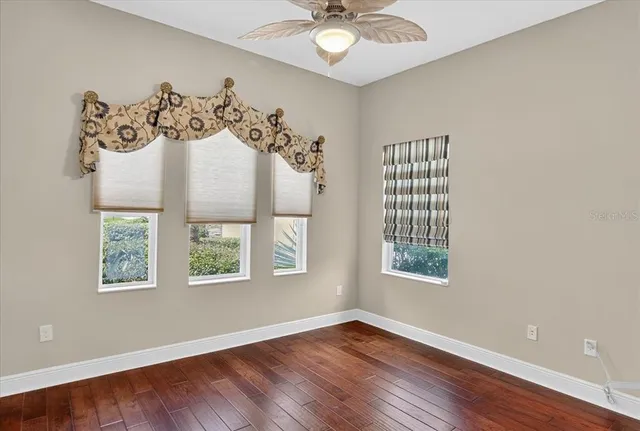 a view of a livingroom with window wooden floor and a chandelier fan