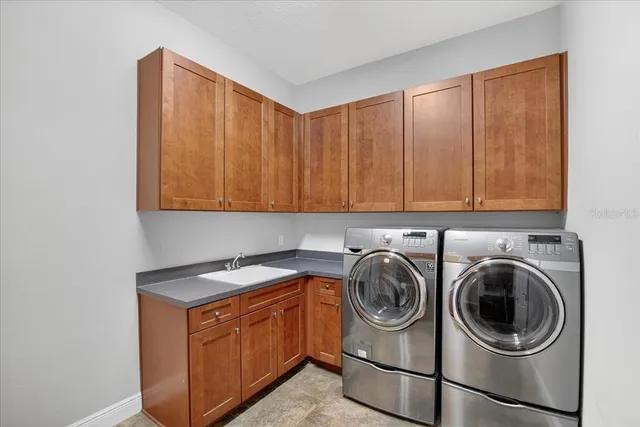 a utility room with sink dryer and washer