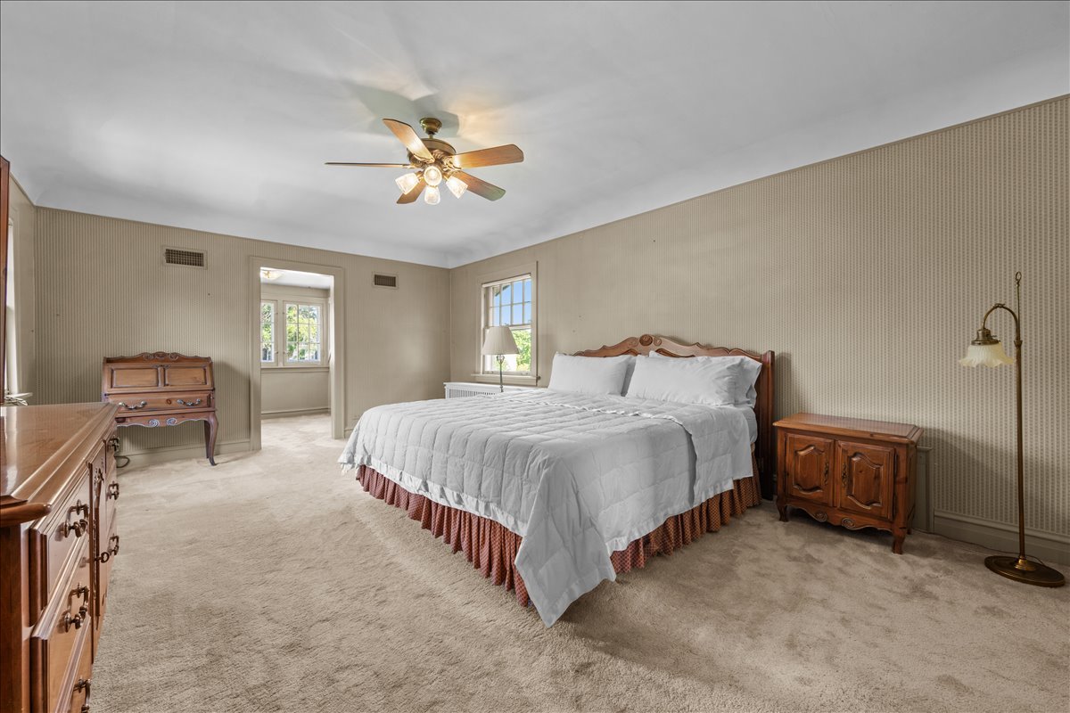 27 Logan Terrace Golf, IL 60029 - Photo 14 of 30 a spacious bedroom with a bed a chandelier and dresser