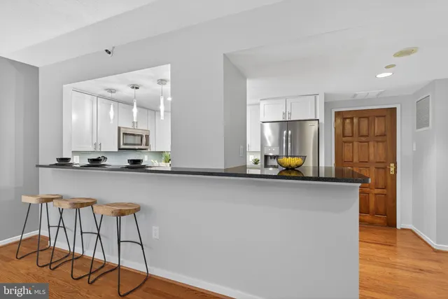 a view of a kitchen with kitchen island granite countertop wooden floor and a window