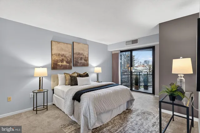 a bedroom with a bed and large windows