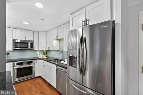 a kitchen with stainless steel appliances a refrigerator sink and cabinets