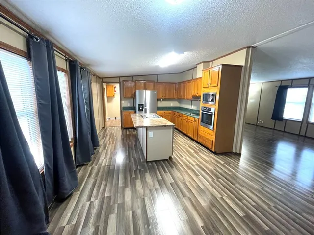 a view of a kitchen with wooden floor and electronic appliances