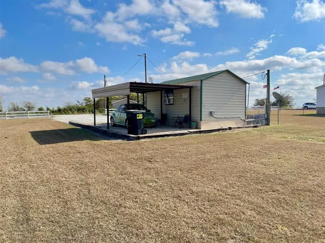 a view of a house with a yard and sitting area