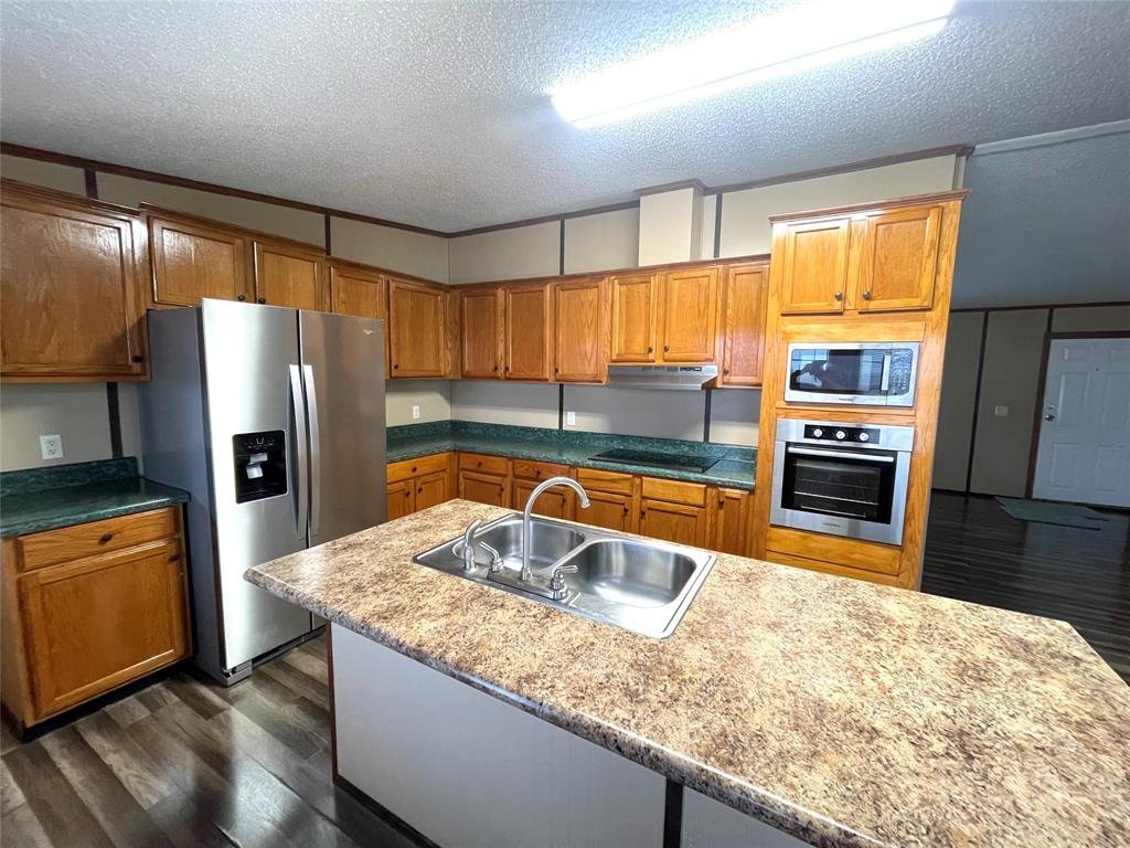 440 Ballman Road Riesel, TX 76682 - Photo 6 of 32 a kitchen with granite countertop a refrigerator and a sink