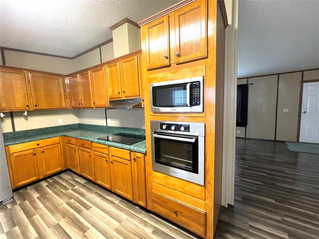 440 Ballman Road Riesel, TX 76682 - Photo 10 of 32 a kitchen with stainless steel appliances granite countertop a stove top oven a sink and cabinets