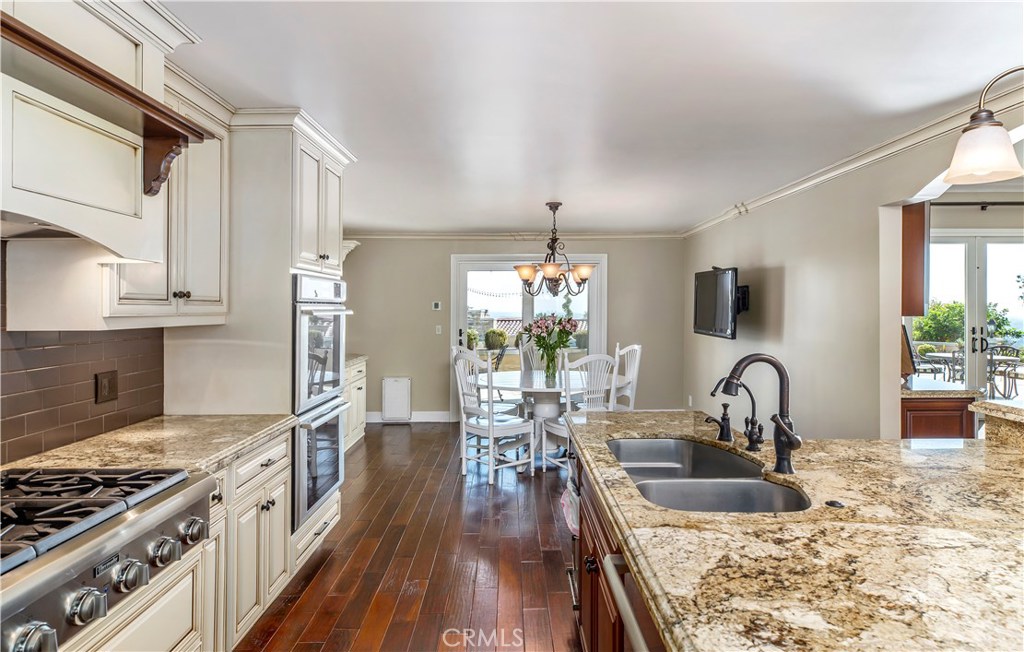 12822 Periwinkle Drive North Tustin, CA 92705 - Photo 15 of 36 a kitchen with granite countertop a sink stove and cabinets