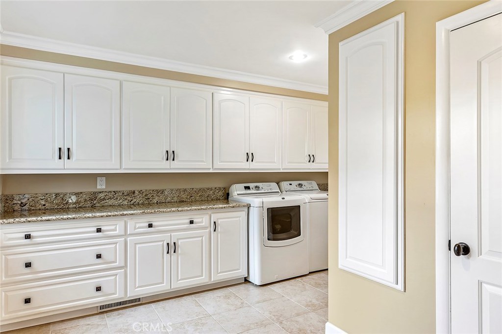 12822 Periwinkle Drive North Tustin, CA 92705 - Photo 31 of 36 a kitchen with granite countertop white cabinets and sink